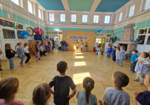 sala gimnastyczna, dzieci stoją w dużym kole
